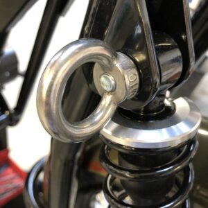 Close-up of a motorcycle suspension's spring and damper with a focus on the attachment ring.