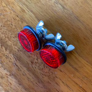 Red bicycle reflectors on a wooden surface.