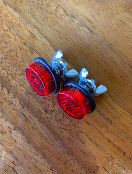 Red bicycle reflectors on a wooden surface.