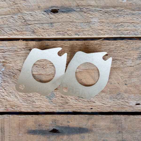 Two cardboard cutouts of glasses on a wooden background.