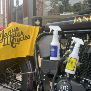 Janus motorcycle with branded towel and cleaning supplies on display.